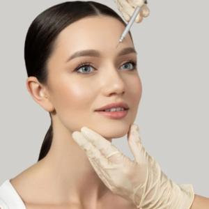 Femme recevant un soin du visage dans un salon de beauté, détendue sur une table de traitement avec des serviettes autour d'elle.