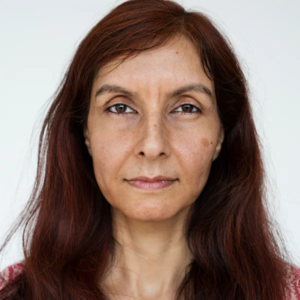 Femme aux longs cheveux, regardant vers la droite, avec un sourire doux sur le visage.
