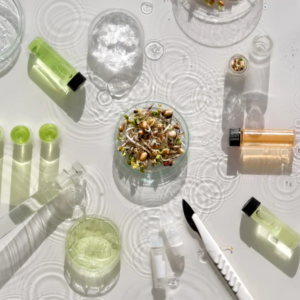 Une variété de produits de beauté disposés sur une surface blanche, incluant des crèmes, rouges à lèvres et parfums.