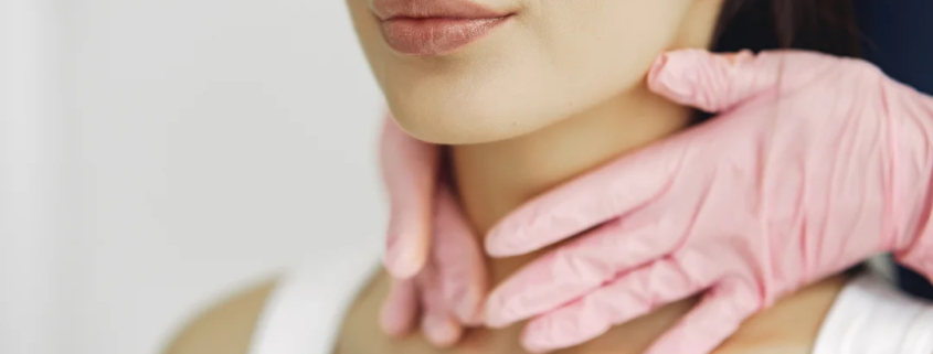 Une femme portant un gant rose autour du cou, affichant une expression de surprise ou de curiosité.