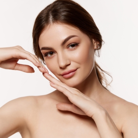 Femme touchant son visage avec ses mains.