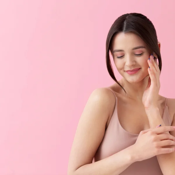 Femme magnifique touchant son visage avec ses mains, exprimant douceur et sérénité.