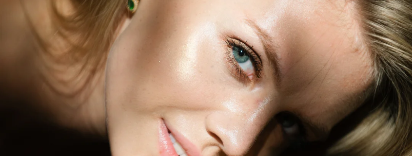 Femme allongée sur le dos, les yeux fermés, évoquant la détente et le soin de la peau avec du collagène.