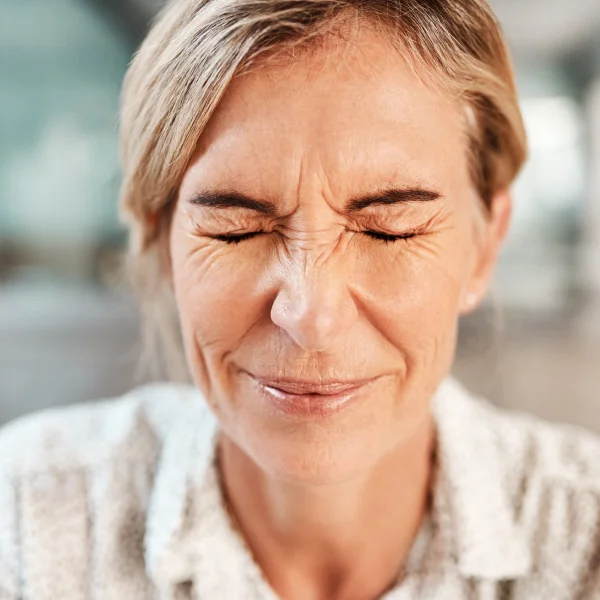 Femme les yeux fermés et la bouche ouverte, recevant un traitement de rajeunissement du visage.