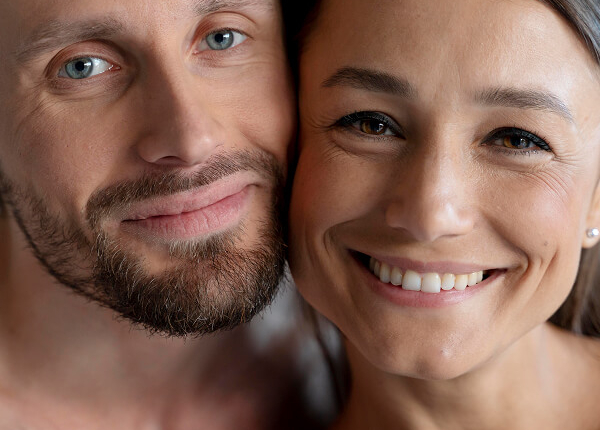 Un homme et une femme posent ensemble pour une photo, souriant, dans un cadre qui évoque des soins esthétiques.